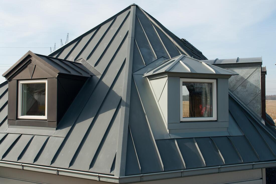 Metal roof on gray attic with two windows