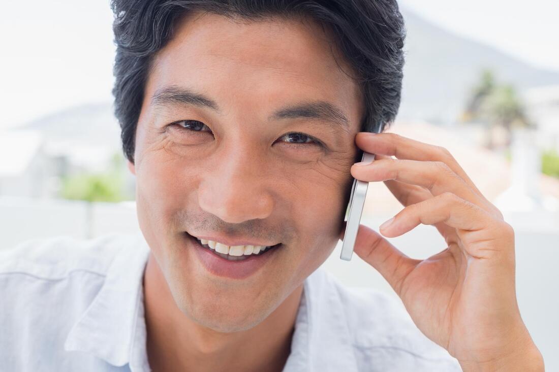 man smiling while his on phone