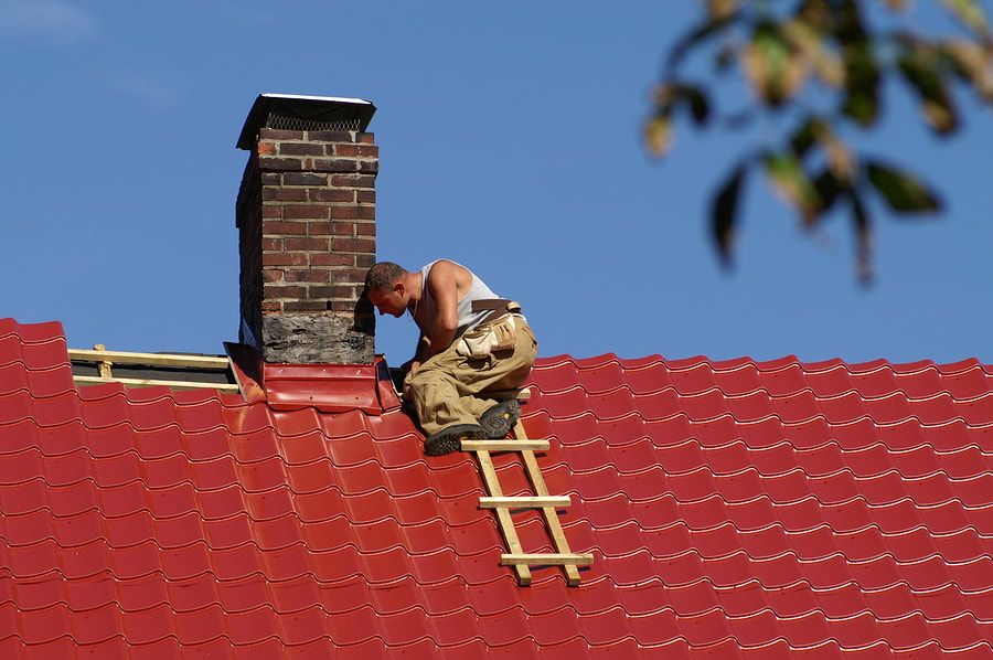 man putting roof tiles around the chimney